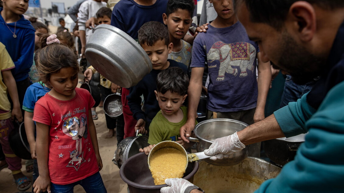 Internally displaced Palestinians receive meals at Jabalia camp, northern Gaza