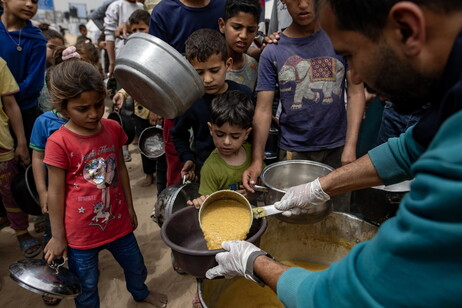 Internally displaced Palestinians receive meals at Jabalia camp, northern Gaza