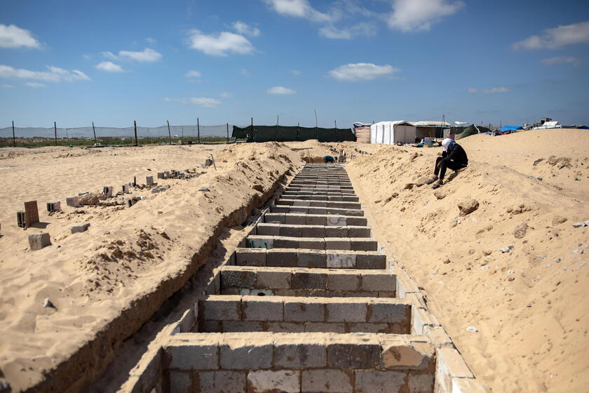 Palestinians make graves from the rubble of Gaza's destroyed homes