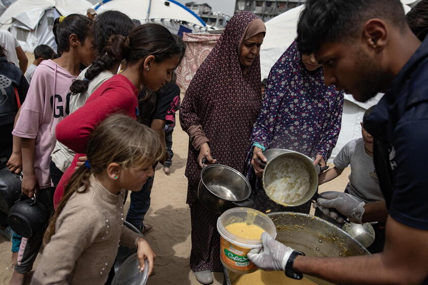 Internally displaced Palestinians receive meals at Jabalia camp, northern Gaza