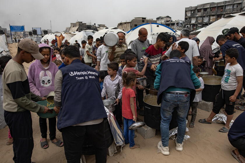 Internally displaced Palestinians receive meals at Jabalia camp, northern Gaza