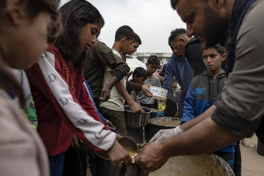 Internally displaced Palestinians receive meals at Jabalia camp, northern Gaza