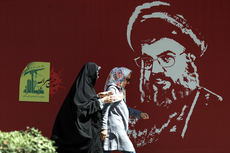 Donne iraniane passano davanti a un ritratto del defunto leader di Hezbollah Nasrallah a Teheran © ANSA/EPA