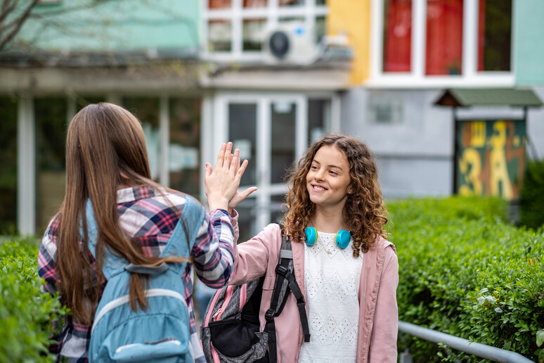 Due ragazzine fuori scuola foto iStock. - RIPRODUZIONE RISERVATA