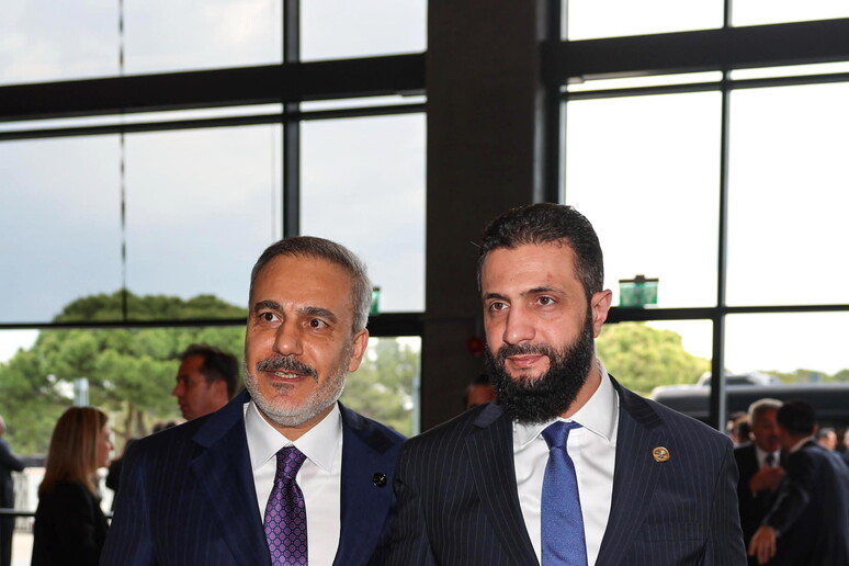 Il leader siriano Al Jolani con il ministro turco Fidan a margine del Forum diplomatico di Antalya © ANSA/EPA