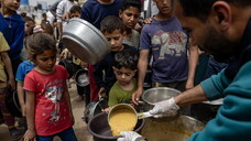 Internally displaced Palestinians receive meals at Jabalia camp, northern Gaza